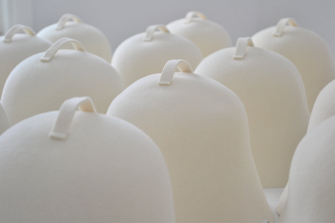A row of white wool sauna hats made in the USA, featuring the high quality and soft Rambouillet wool better than merino