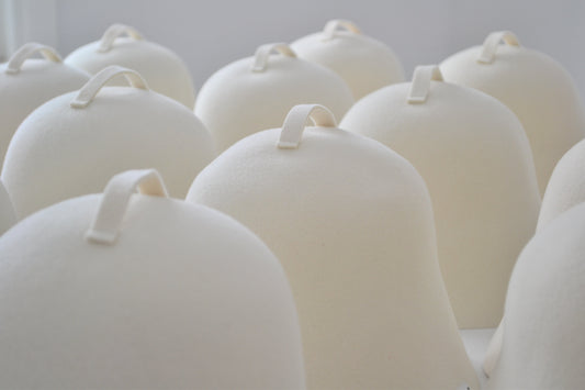 A row of white wool sauna hats made in the USA, featuring the high quality and soft Rambouillet wool better than merino